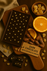 Dark chocolate bar with orange and ginger on a wooden board, surrounded by ingredients.